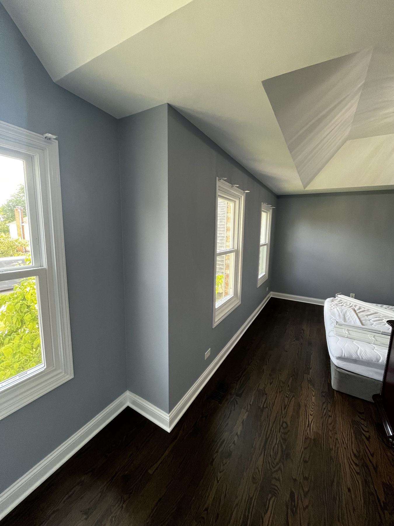 Bedroom with walls repainted in gray-blue and white trim